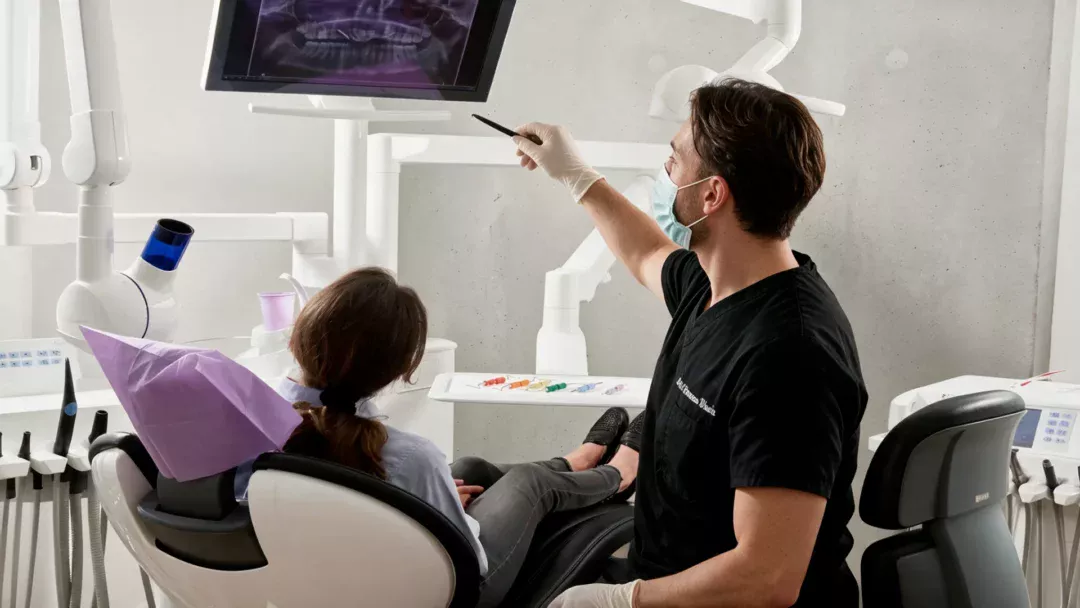 Il dottore mostra alla paziente la radiografia sul monitor durante la valutazione diagnostica