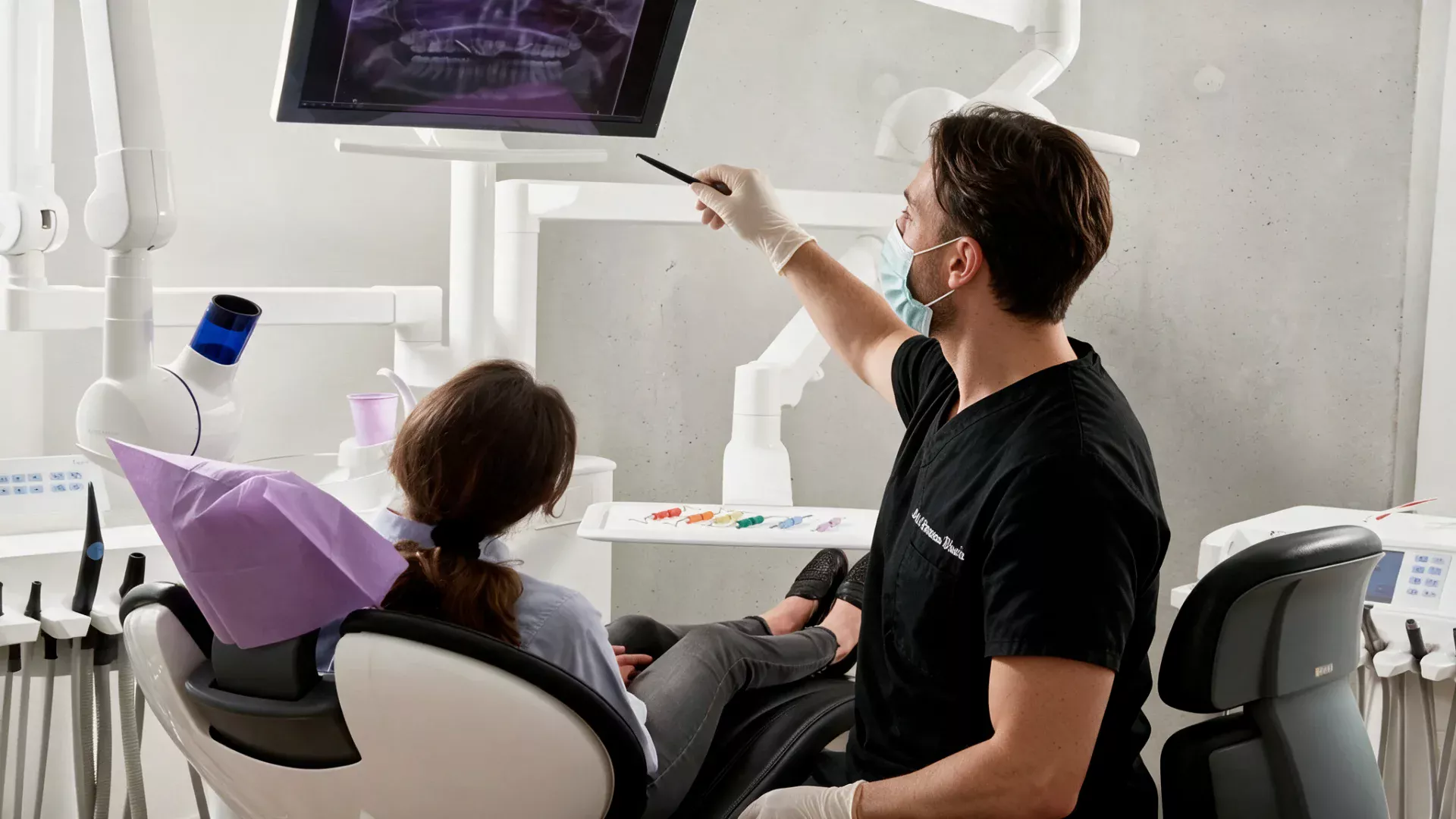 Il dottore mostra alla paziente la radiografia sul monitor durante la valutazione diagnostica